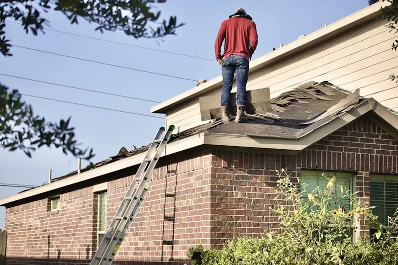 Professional roofer working on a residential roof in Mohegan